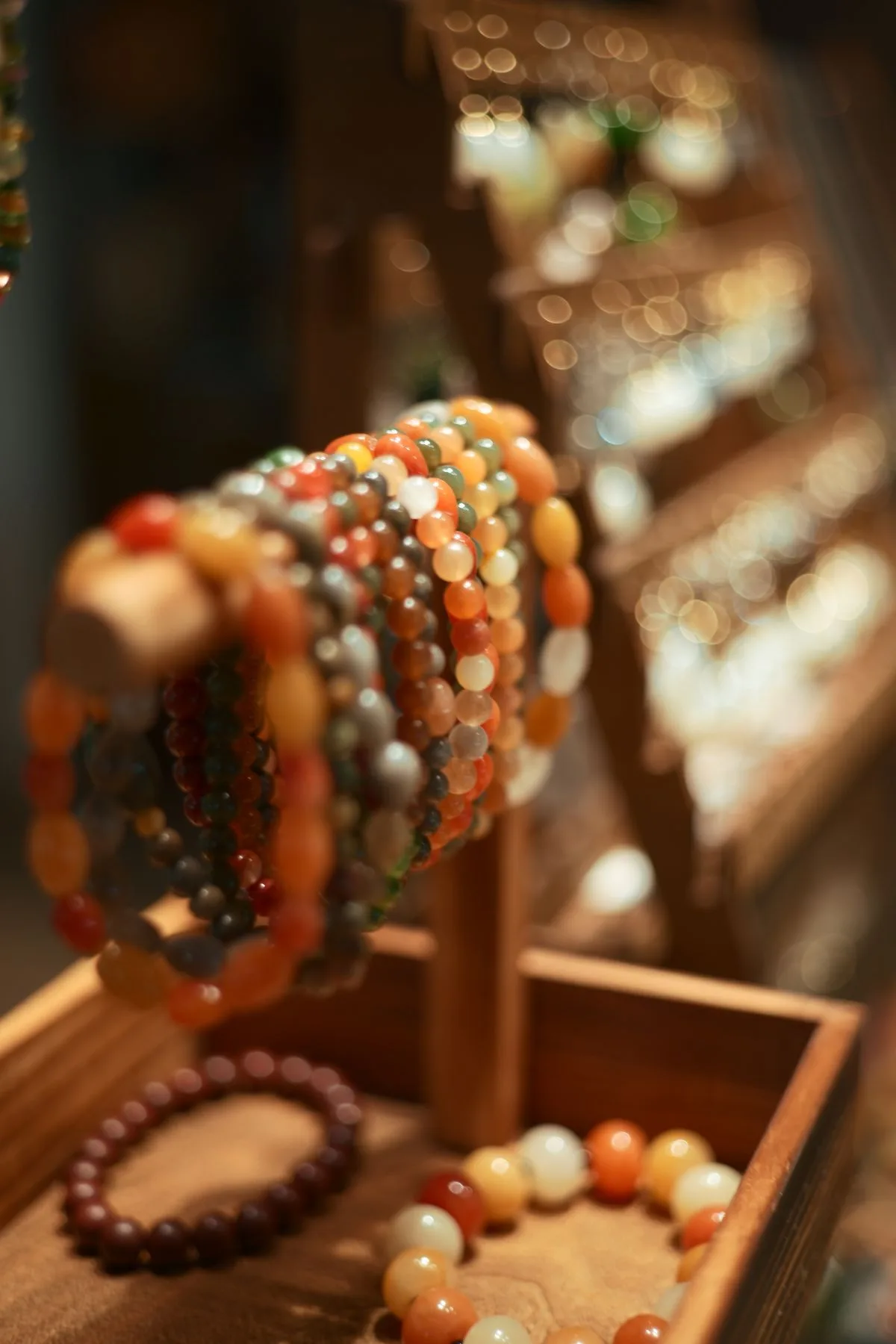 Studio display of warm agate and gemstone beaded bracelets