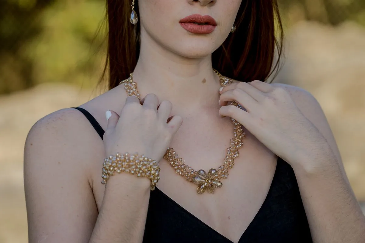 Model wearing layered champagne beaded necklace and bracelet